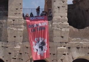 Activistas despliegan pancarta en el Coliseo por "Desarmar la Tierra"