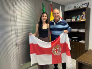 Antonio Casimiro entrega una bandera de Almería a Inés Ortega para que la exhiba en sus próximos éxitos